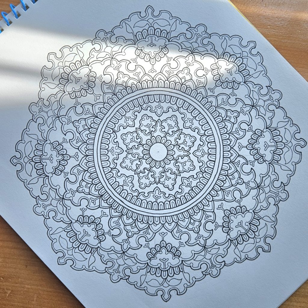 Black and white mandala art created by Noor Khan with fineliner pens on mixed media paper